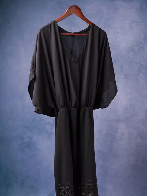 Black wrap dress with lace hem on a hanger