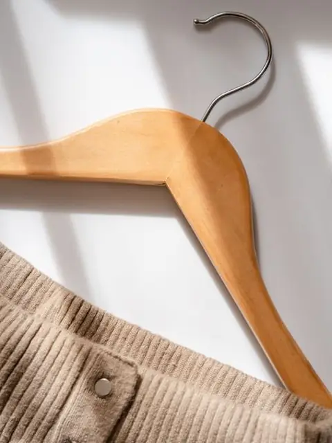 Camel corduroy skirt on a wooden hanger with black sunglasses