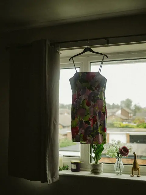 Floral cami mini dress on a hanger in a window