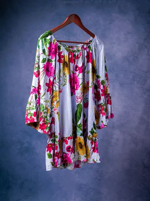 Bright floral dress on a wooden hanger