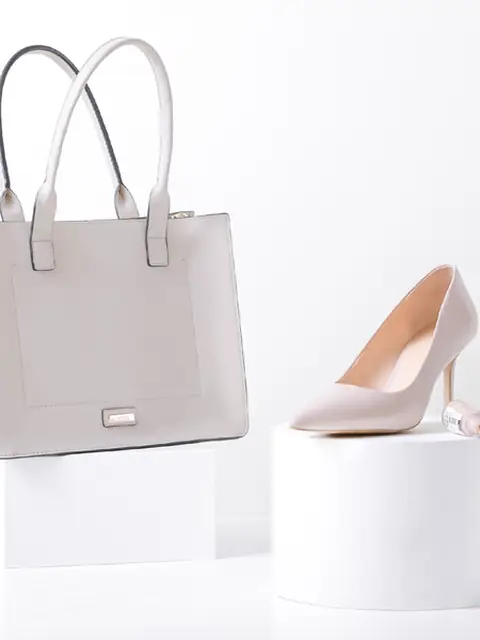 Pale grey structured tote beside a nude pump