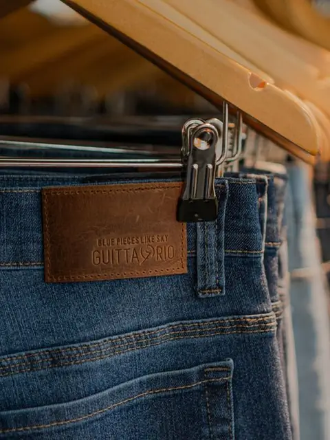 Close-up of dark denim jeans on hangers
