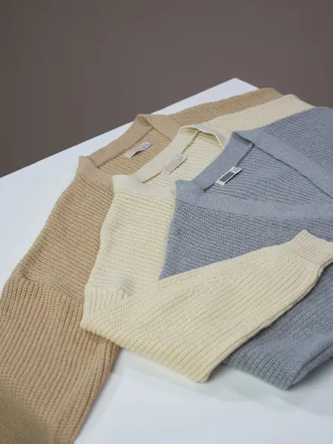 Three fine-knit polo sweaters in sand, cream and grey