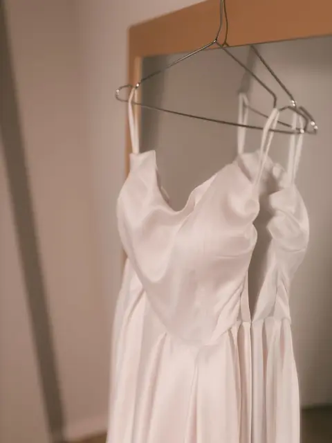 Ivory satin slip dress on a wire hanger